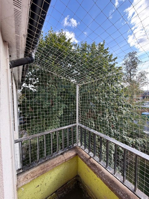 Bird netting enclosing the corner of a residential balcony