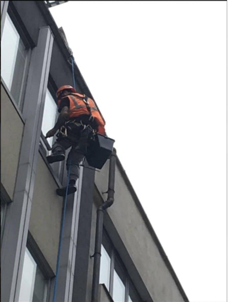 IRATA technician descending a building facade on rope